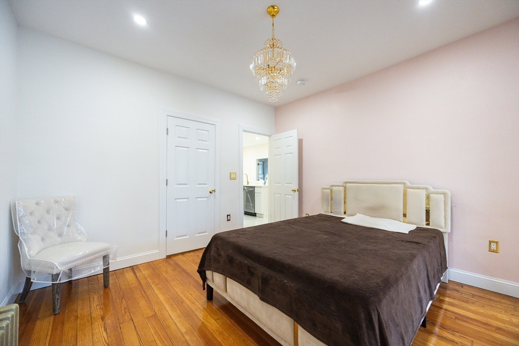 12 Lothrop Street Saugus, MA 01906 - Photo 15 of 42 a bedroom with a bed and a chandelier