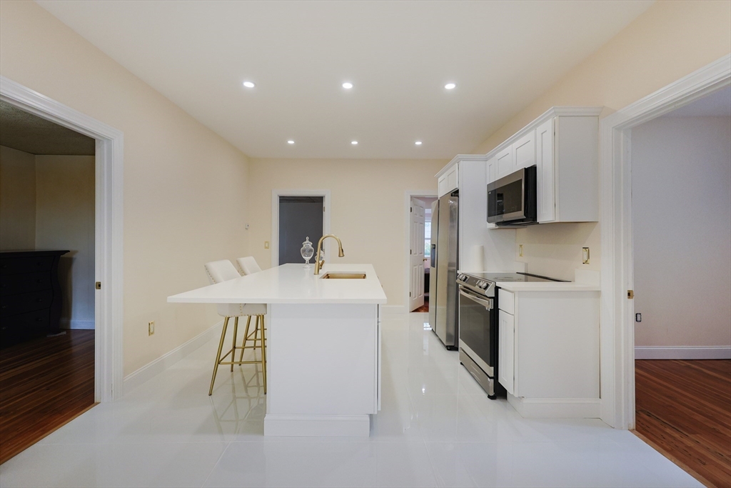12 Lothrop Street Saugus, MA 01906 - Photo 5 of 42 a kitchen with a sink a refrigerator and a stove top oven