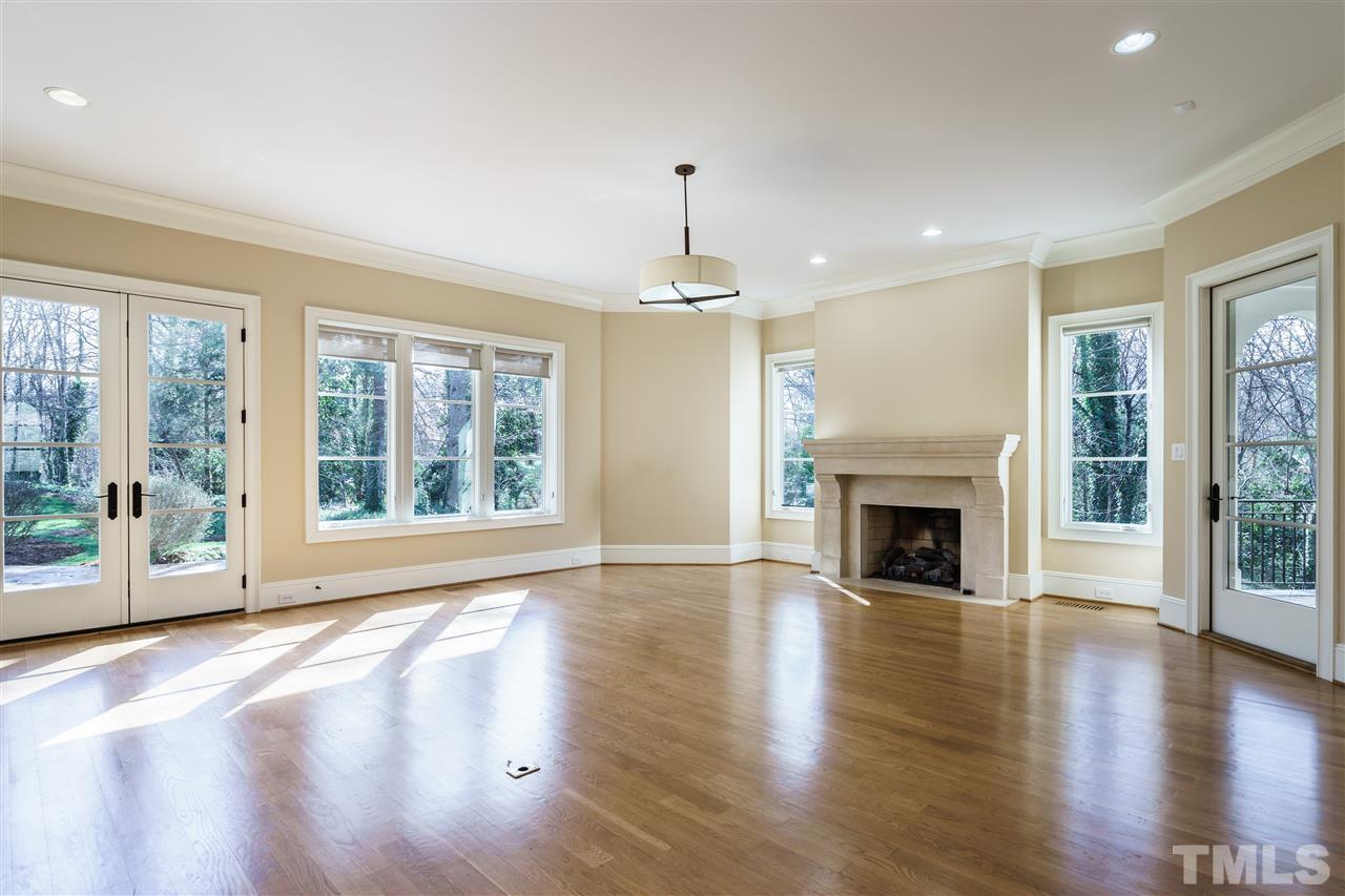 2114 Buckingham Road Raleigh, NC 27607 - Photo 11 of 25 an empty room with floor to ceiling windows and a fireplace