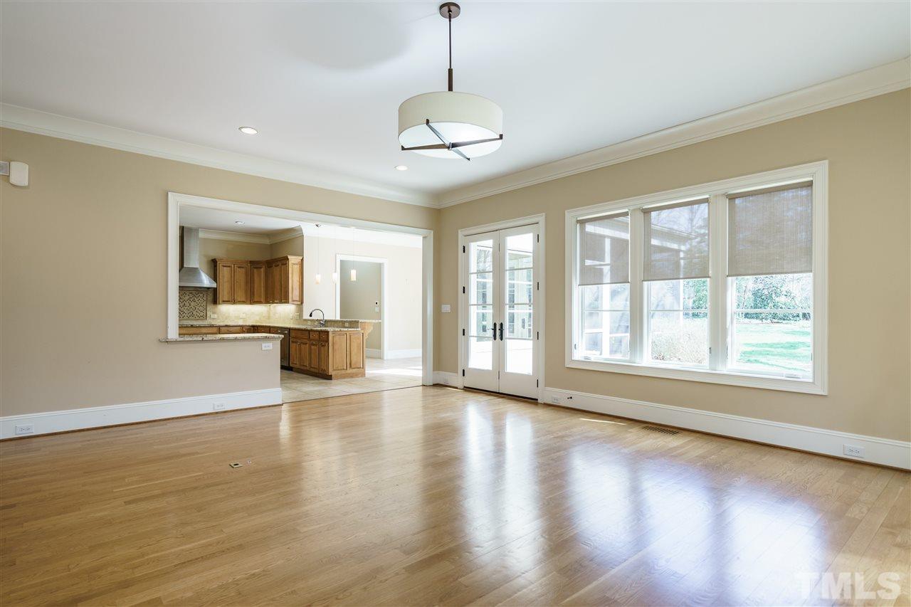 2114 Buckingham Road Raleigh, NC 27607 - Photo 12 of 25 a view of an empty room with wooden floor and a window