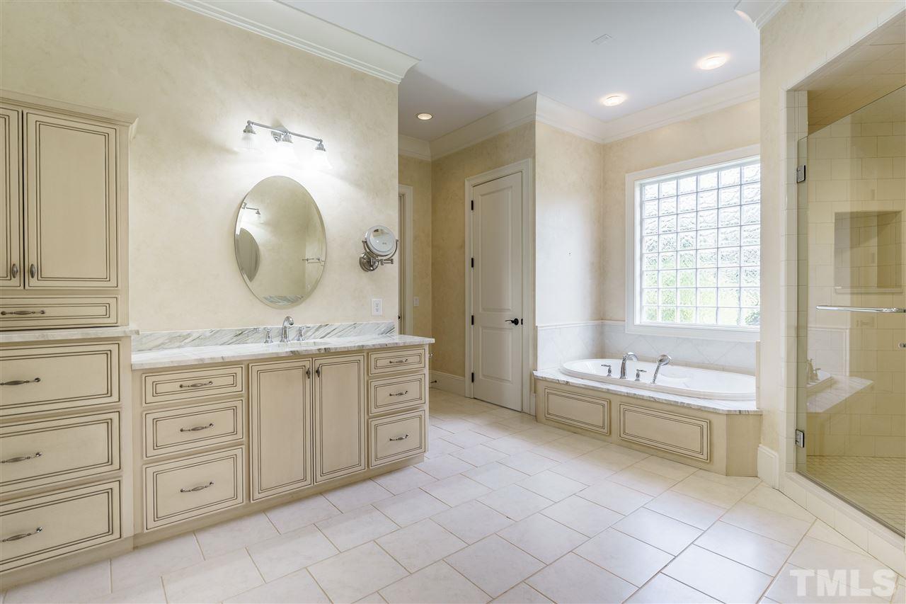 2114 Buckingham Road Raleigh, NC 27607 - Photo 16 of 25 a spacious bathroom with a double vanity sink a mirror a bathtub and next to a window