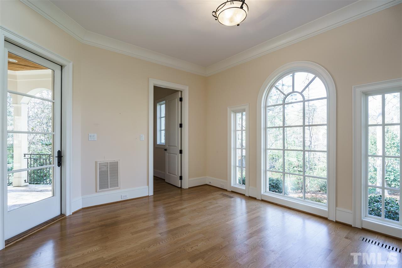 2114 Buckingham Road Raleigh, NC 27607 - Photo 4 of 25 a view of an empty room with wooden floor and a window