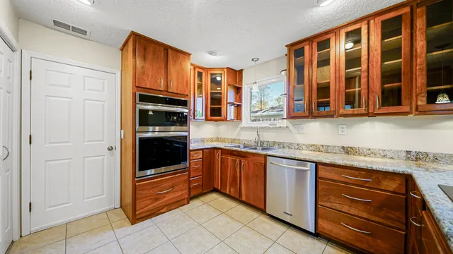 a kitchen with stainless steel appliances granite countertop a sink dishwasher stove and cabinets