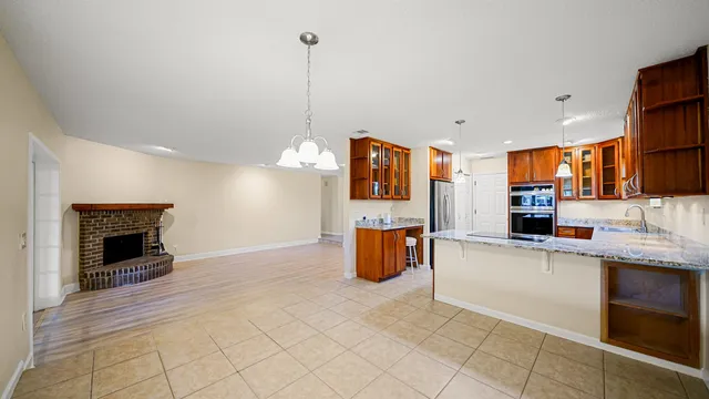 a kitchen with stainless steel appliances kitchen island granite countertop a stove a sink and a refrigerator
