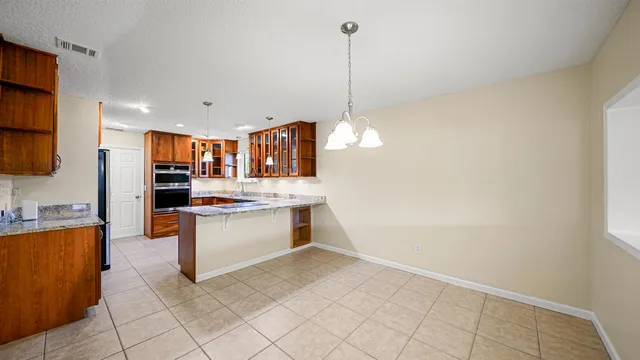a kitchen with stainless steel appliances granite countertop a refrigerator and a stove top oven