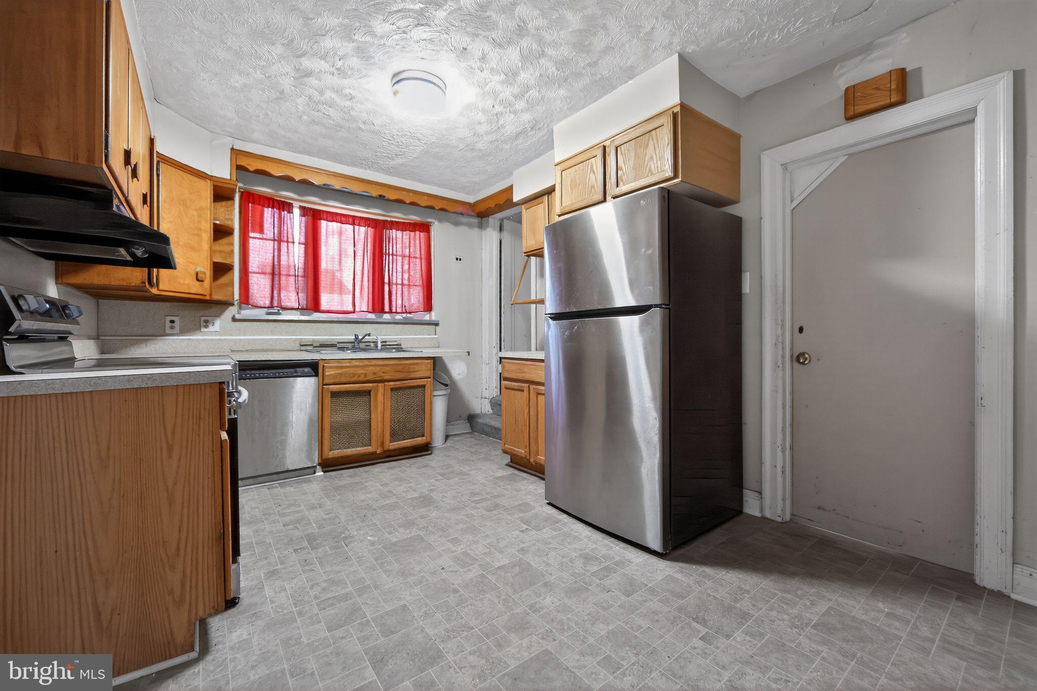 6448 Cherokee Street Philadelphia, PA 19119 - Photo 14 of 33 a kitchen with refrigerator a microwave and red stove
