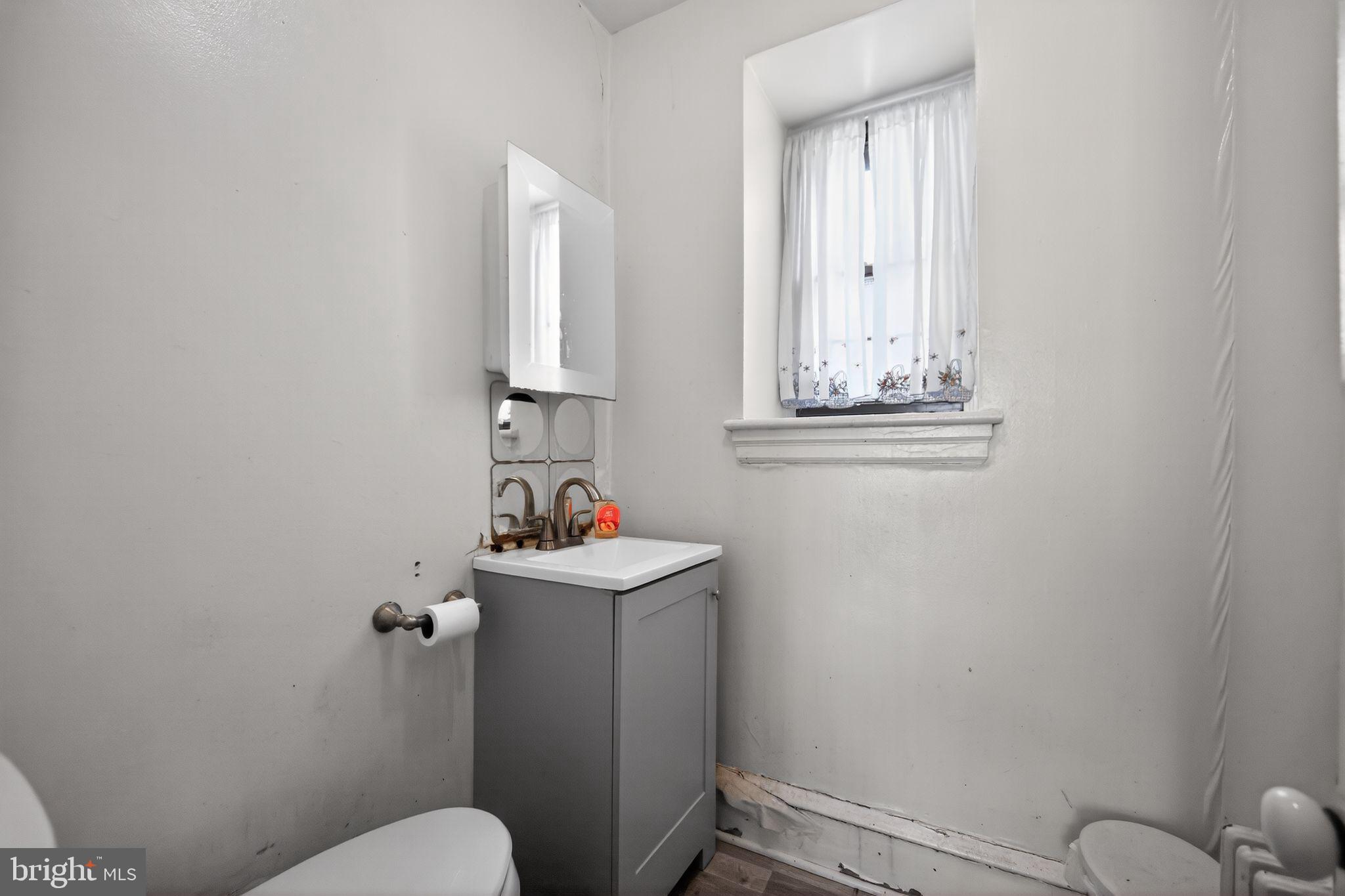 6448 Cherokee Street Philadelphia, PA 19119 - Photo 16 of 33 a bathroom with a toilet a sink and mirror