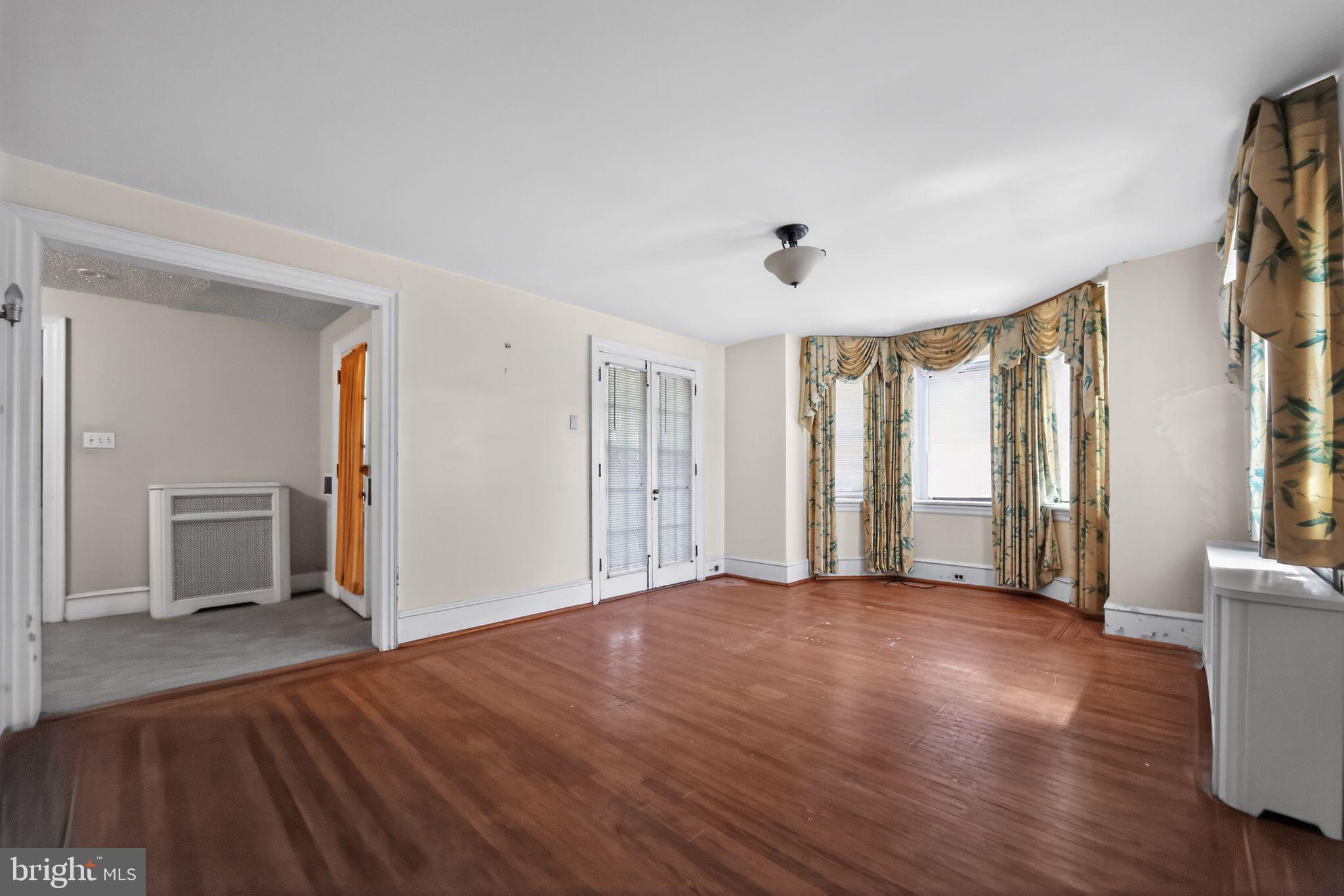 6448 Cherokee Street Philadelphia, PA 19119 - Photo 8 of 33 a view of an empty room with wooden floor and a window