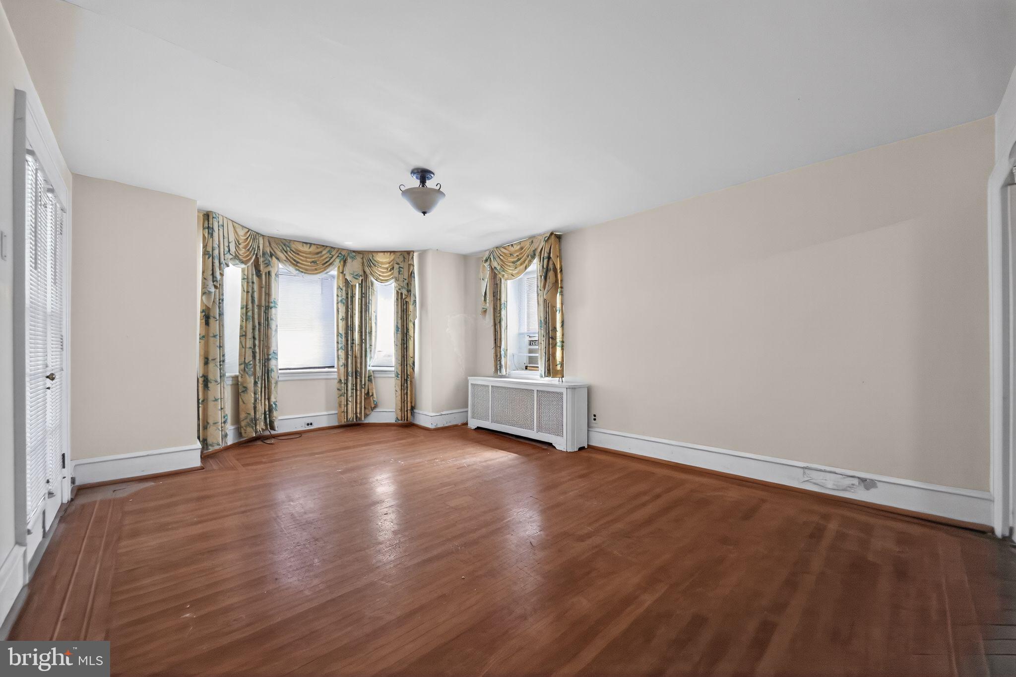 6448 Cherokee Street Philadelphia, PA 19119 - Photo 9 of 33 an empty room with wooden floor and windows