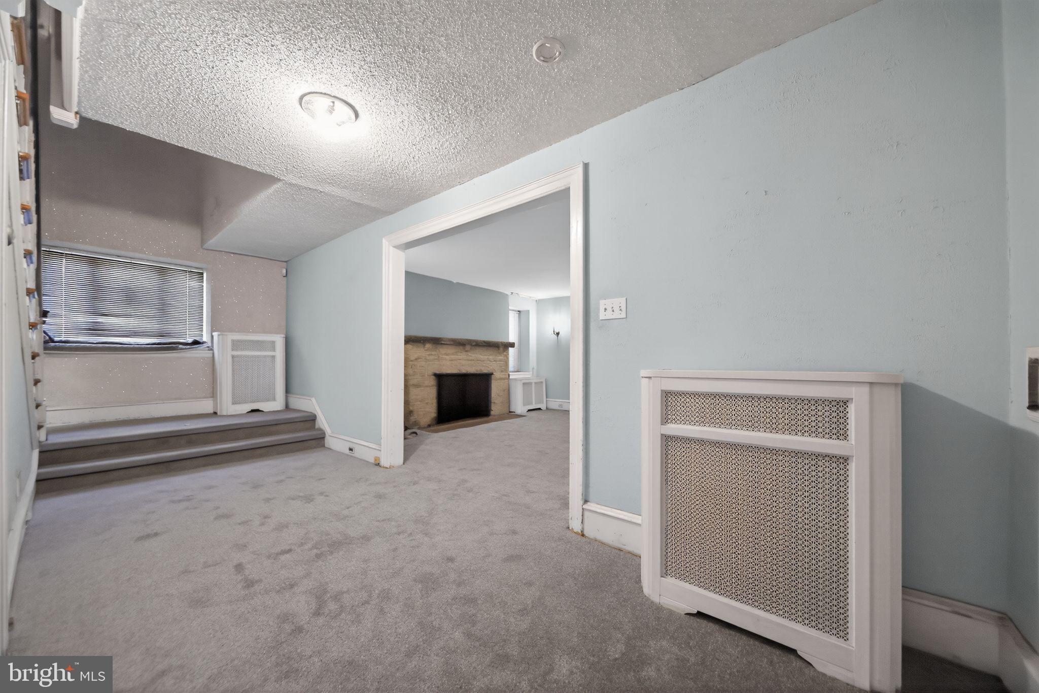 6448 Cherokee Street Philadelphia, PA 19119 - Photo 10 of 33 an empty room with fireplace and windows