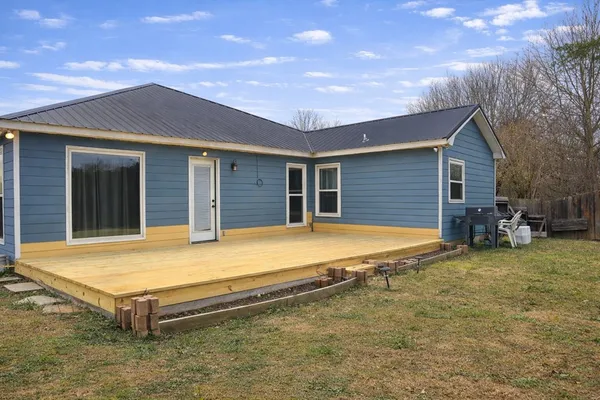 a view of an house with backyard space and balcony