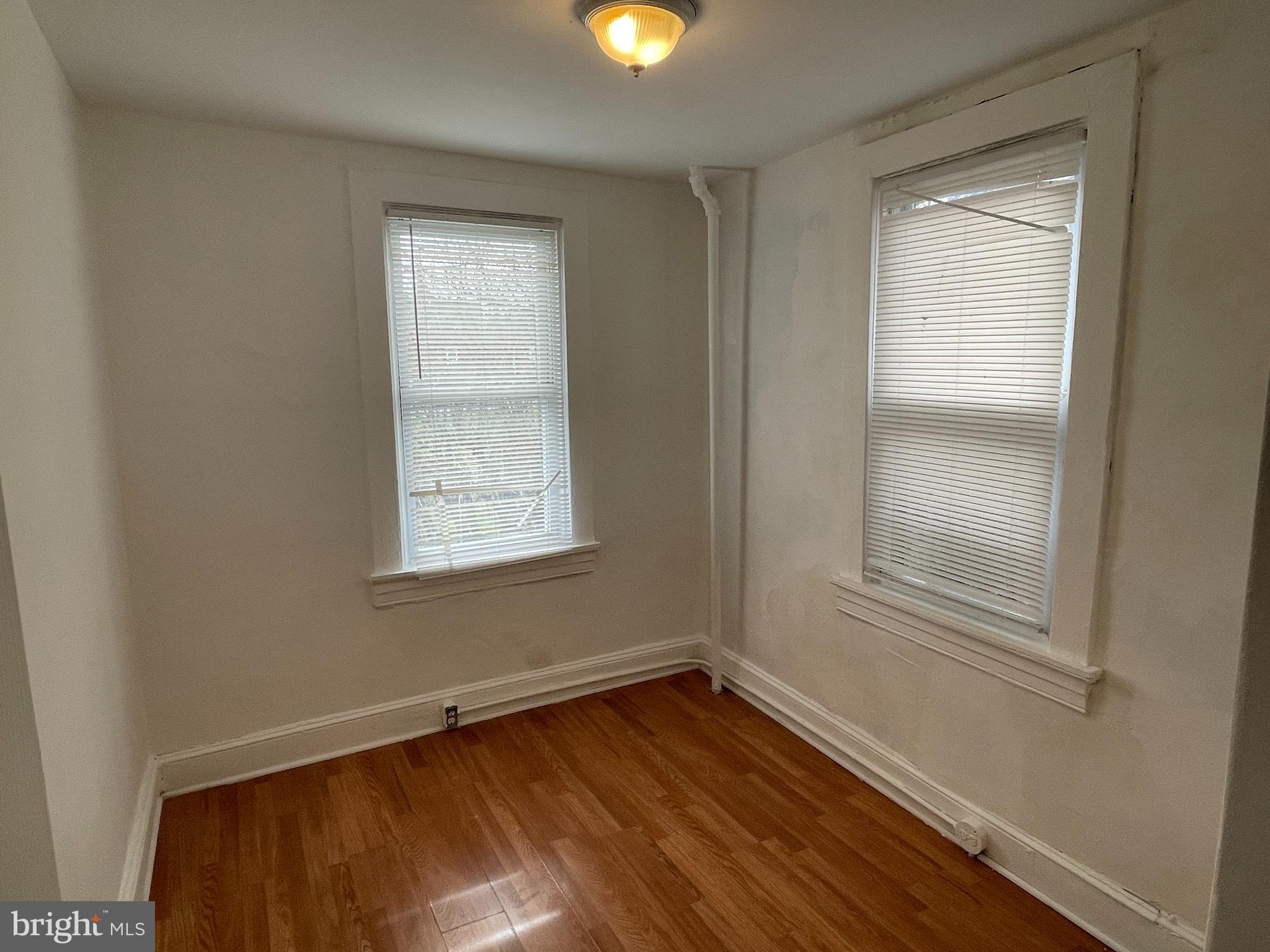 1314 Division Street Baltimore, MD 21217 - Photo 11 of 20 a view of an empty room with wooden floor and a window