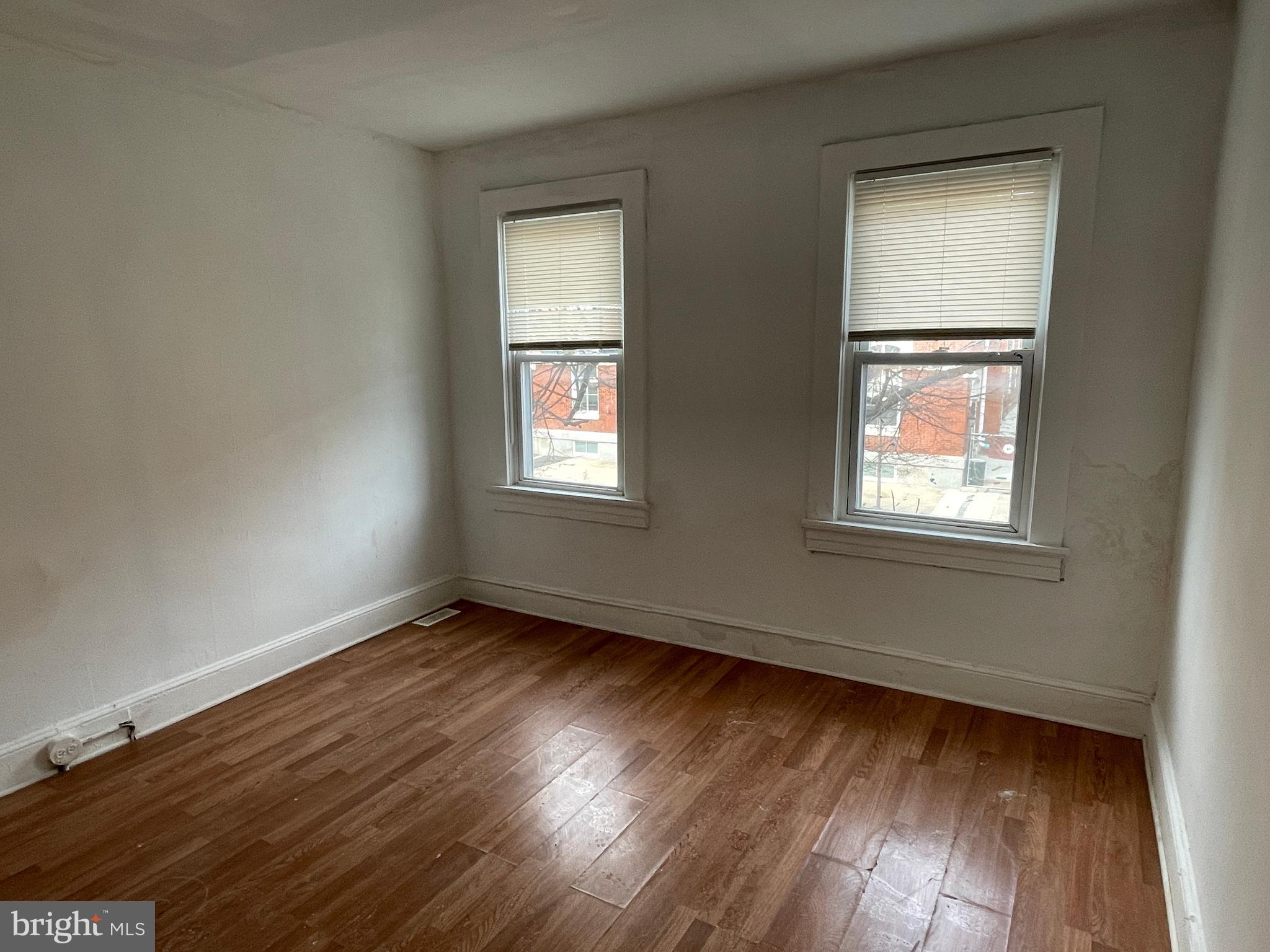1314 Division Street Baltimore, MD 21217 - Photo 9 of 20 a view of an empty room with wooden floor and a window