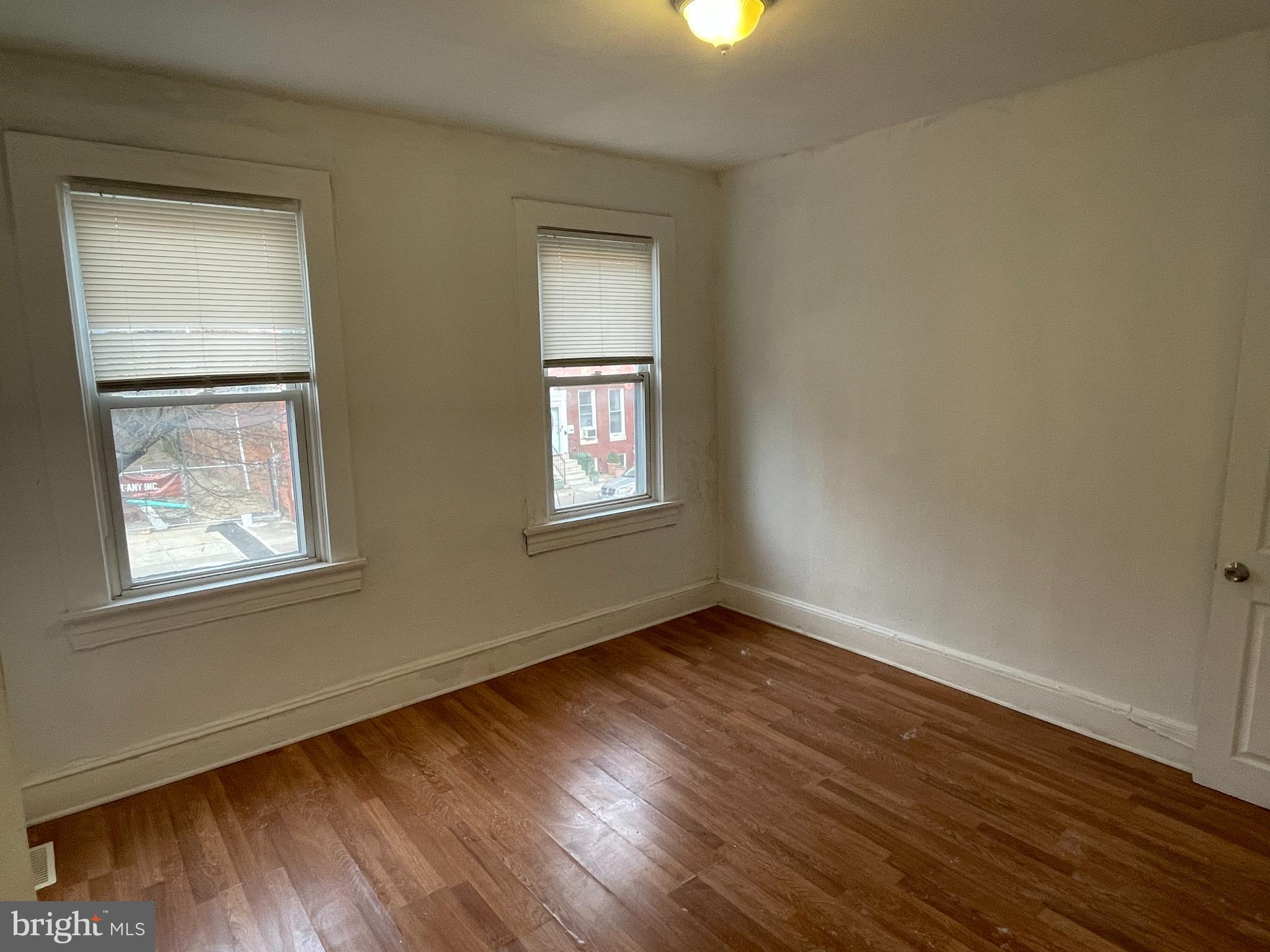 1314 Division Street Baltimore, MD 21217 - Photo 10 of 20 a view of an empty room with wooden floor and a window