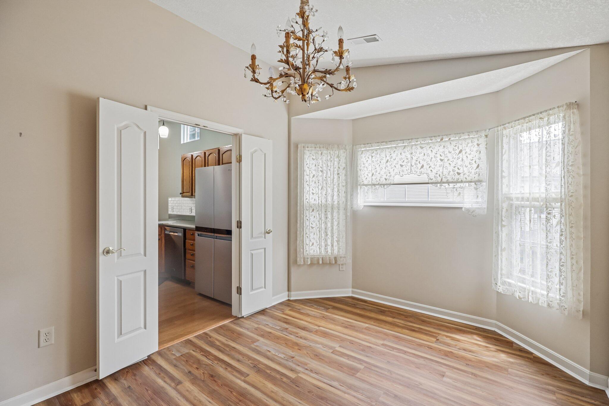 876 Flint Ridge Newport, KY 41076 - Photo 18 of 43 Dining area featuring wood-finish flooring, a decorative chandelier, and a bay window with multiple panes