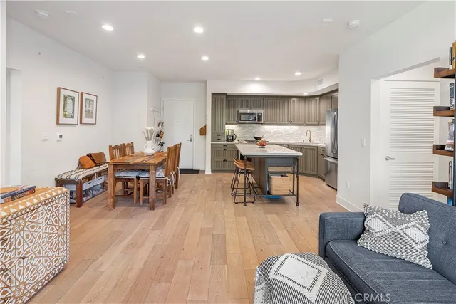 a living room with furniture and a dining table with rug