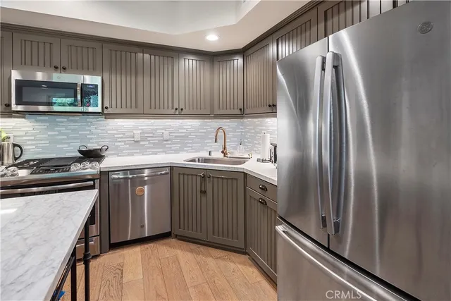 a kitchen with stainless steel appliances granite countertop a refrigerator sink and stove