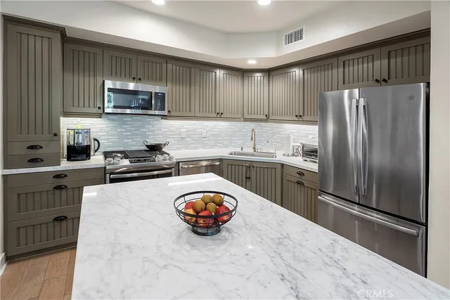 a kitchen with stainless steel appliances a refrigerator sink and microwave