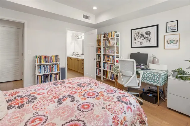 a bedroom with a bed a desk and a book shelf
