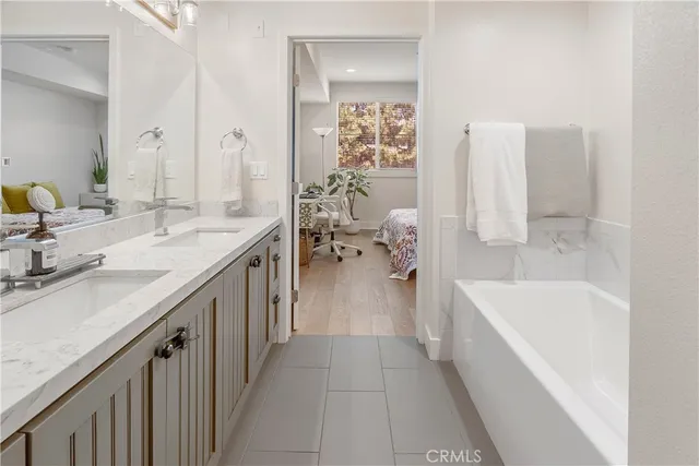 a bathroom with a tub sink and mirror