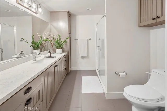 a spacious bathroom with a double vanity sink toilet and shower