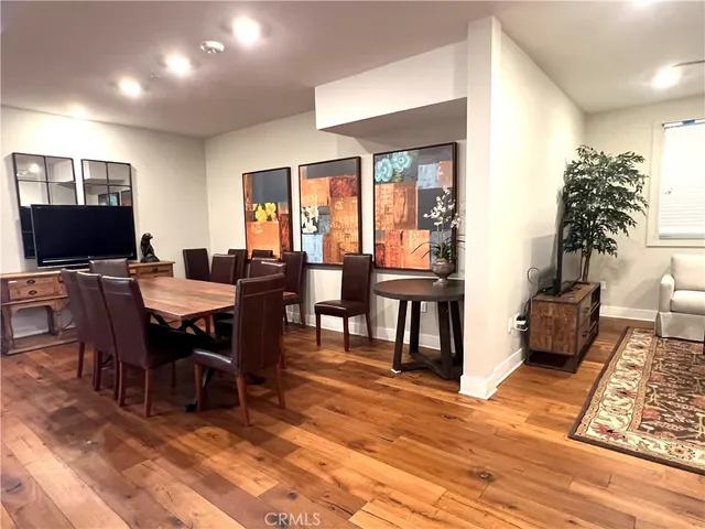 a view of a a dining room with furniture window and wooden floor