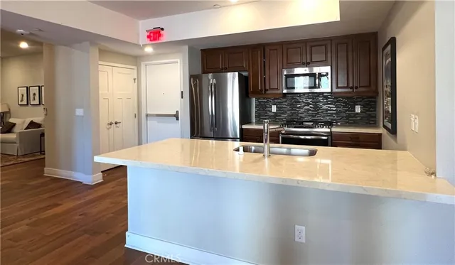 a kitchen with kitchen island a counter top space a sink and appliances