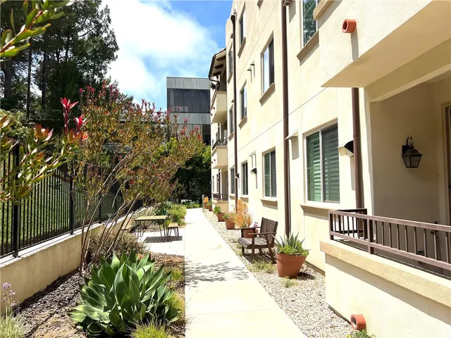 a view of a patio with couches table and chairs and potted plants