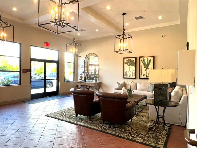a living room with furniture a chandelier and a dining table