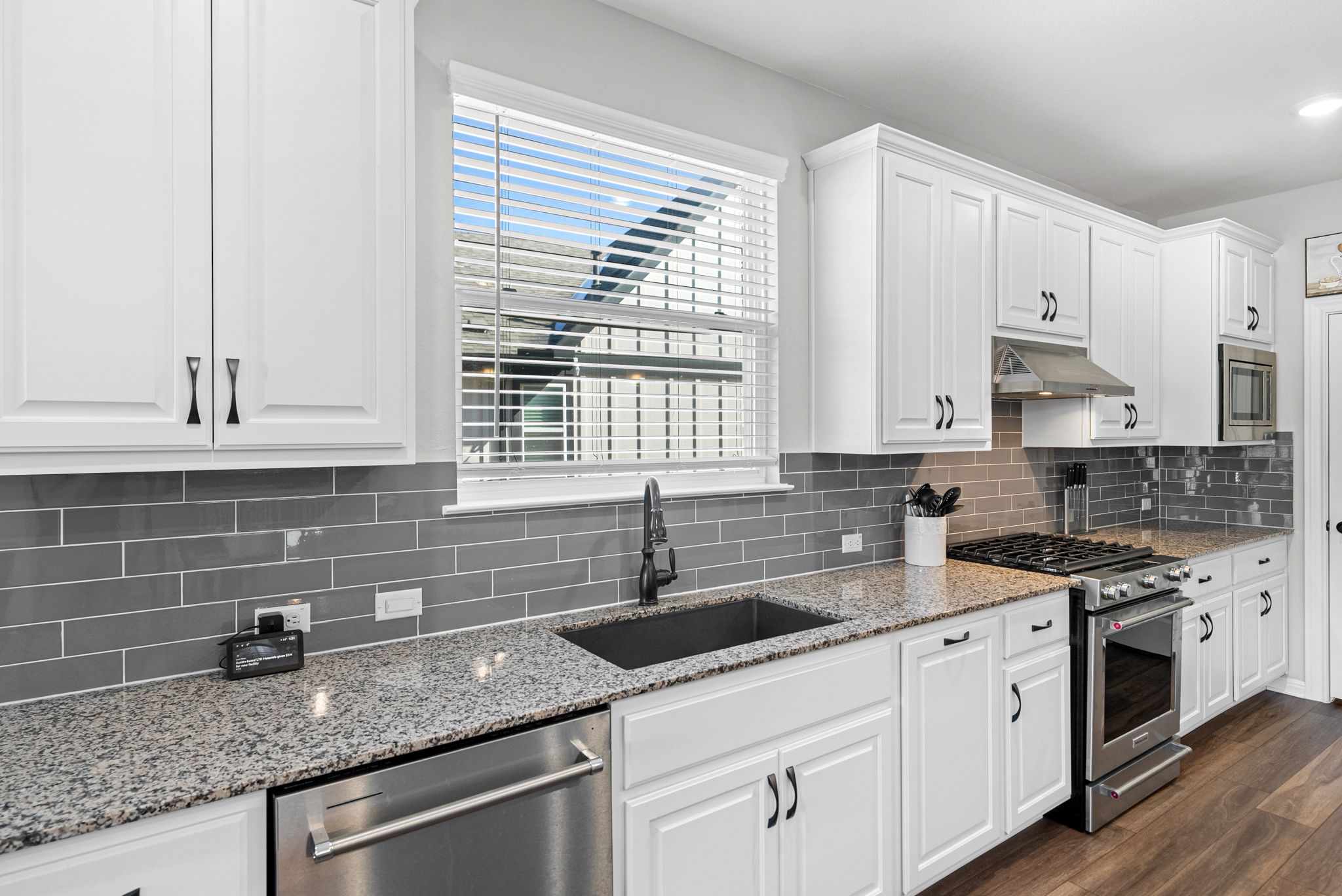 642 Martingale Street Georgetown, TX 78633 - Photo 12 of 40 A deep, under-mount composite sink is paired with a sleek black gooseneck faucet and a classic gray subway tile backsplash to complete this stunning kitchen.