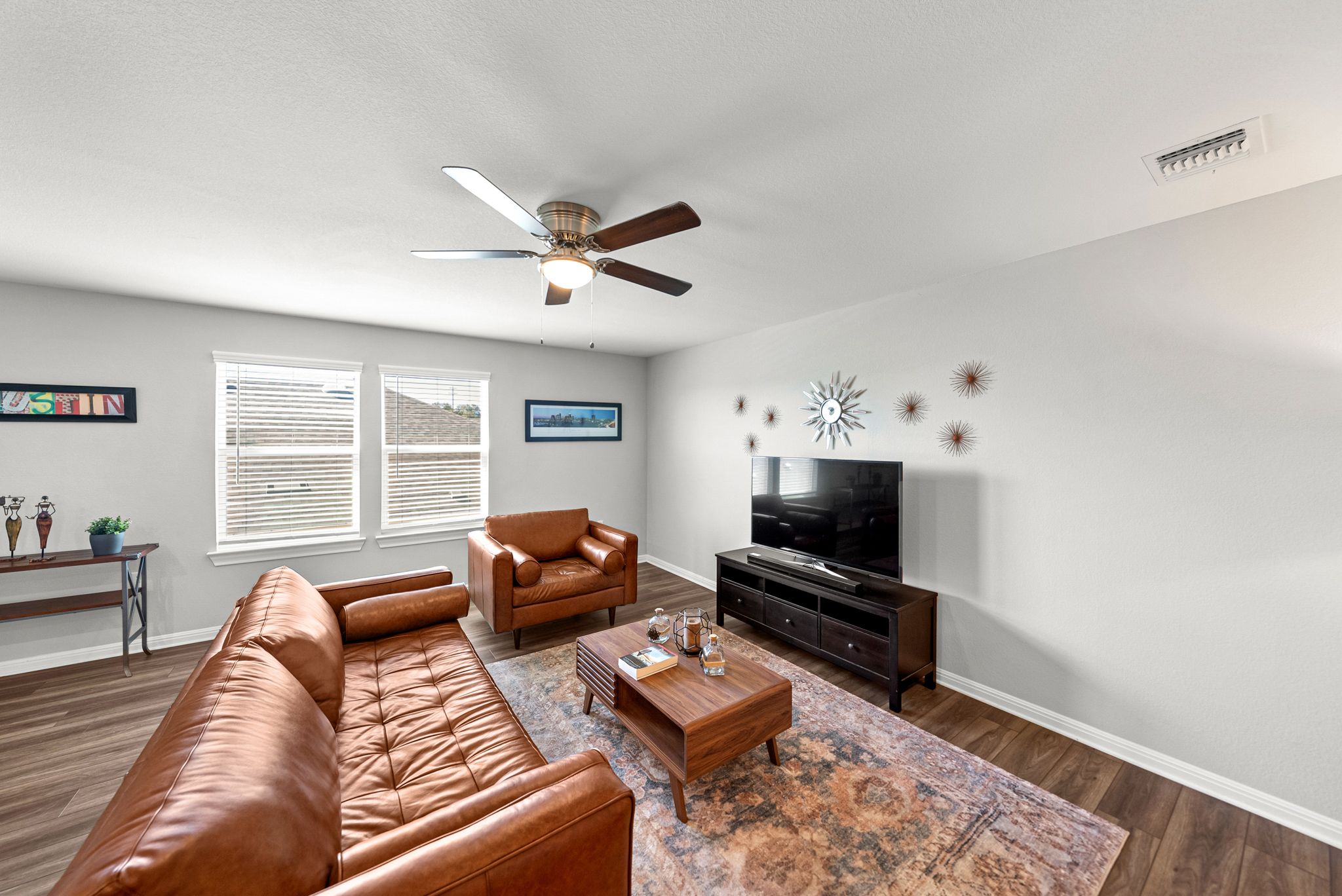 642 Martingale Street Georgetown, TX 78633 - Photo 28 of 40 Large windows and high ceilings make the upstairs loft feel incredibly open. The durable LVP flooring continues here, offering a sophisticated look that is easy to maintain.