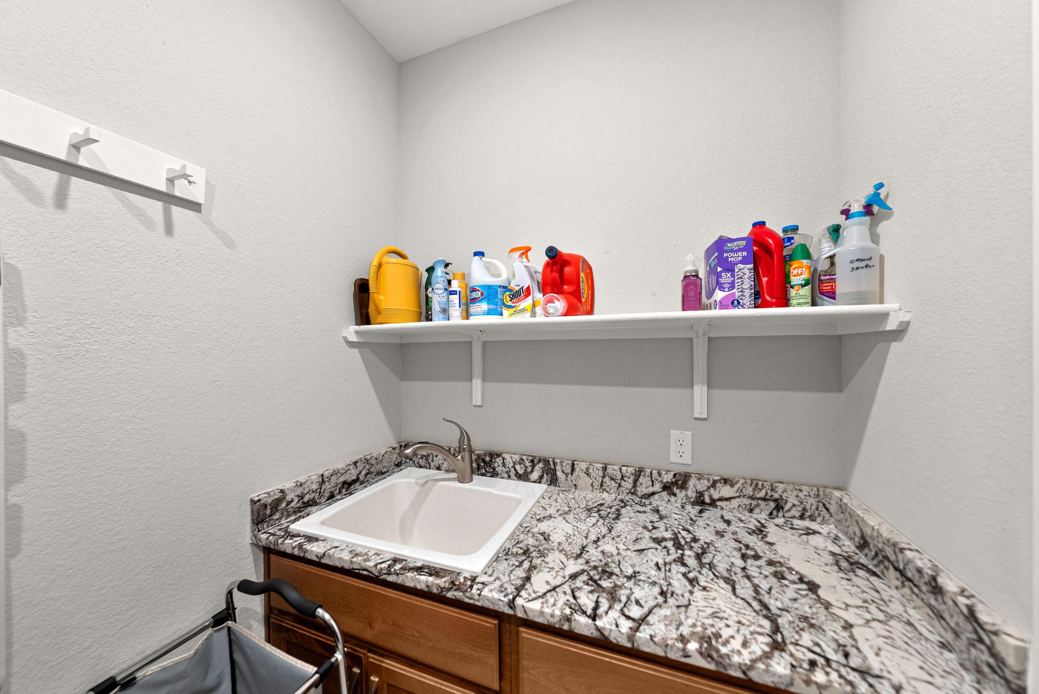 642 Martingale Street Georgetown, TX 78633 - Photo 34 of 40 The dedicated laundry room includes a convenient utility sink and granite countertops, perfect for pre-treating stains or quick cleanups after a day in the garden.