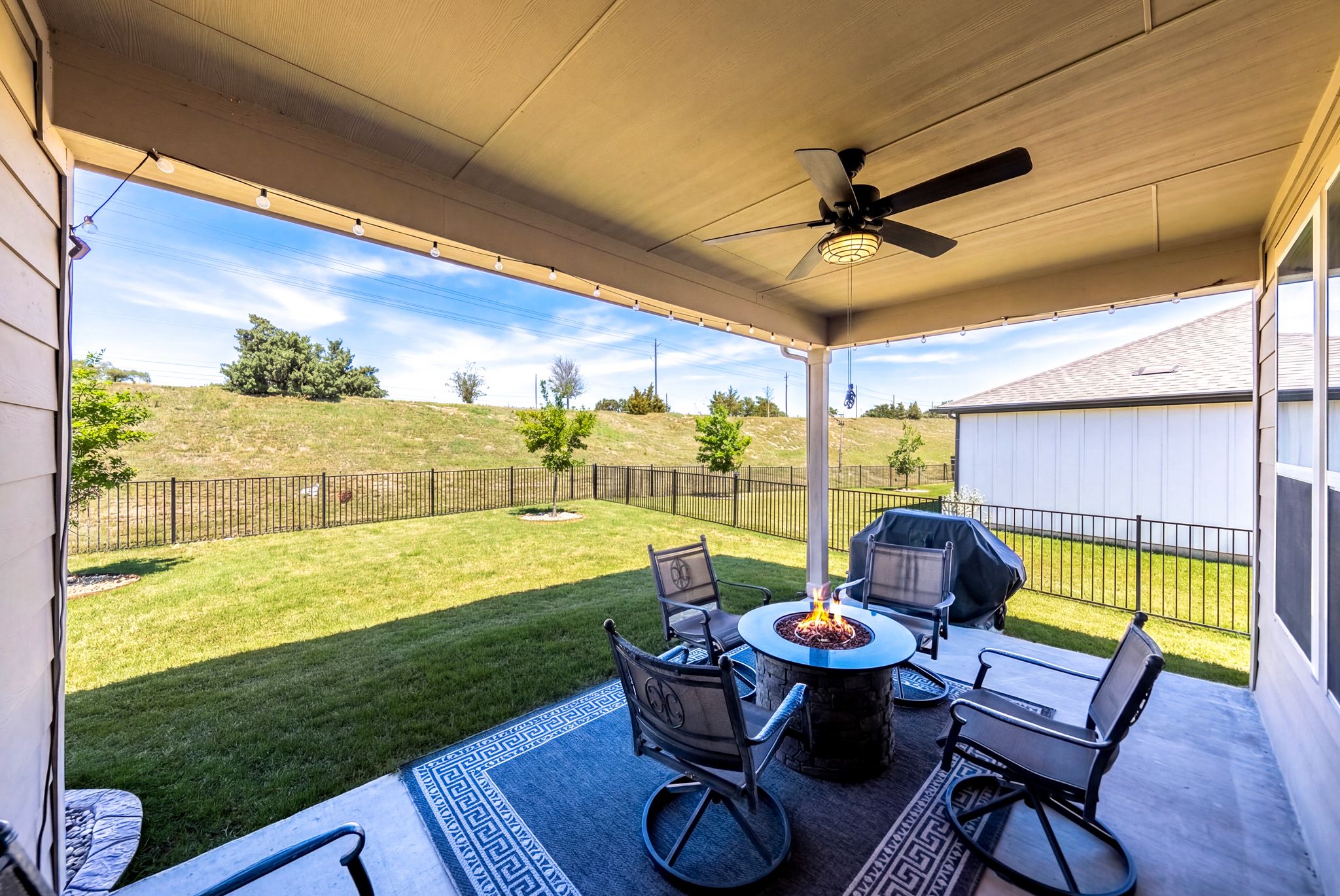 642 Martingale Street Georgetown, TX 78633 - Photo 35 of 40 Enjoy year-round outdoor living on this spacious covered patio. Complete with a cooling ceiling fan, decorative string lighting, and plenty of room for a fire pit lounge, it’s the perfect spot for evening cocktails.
