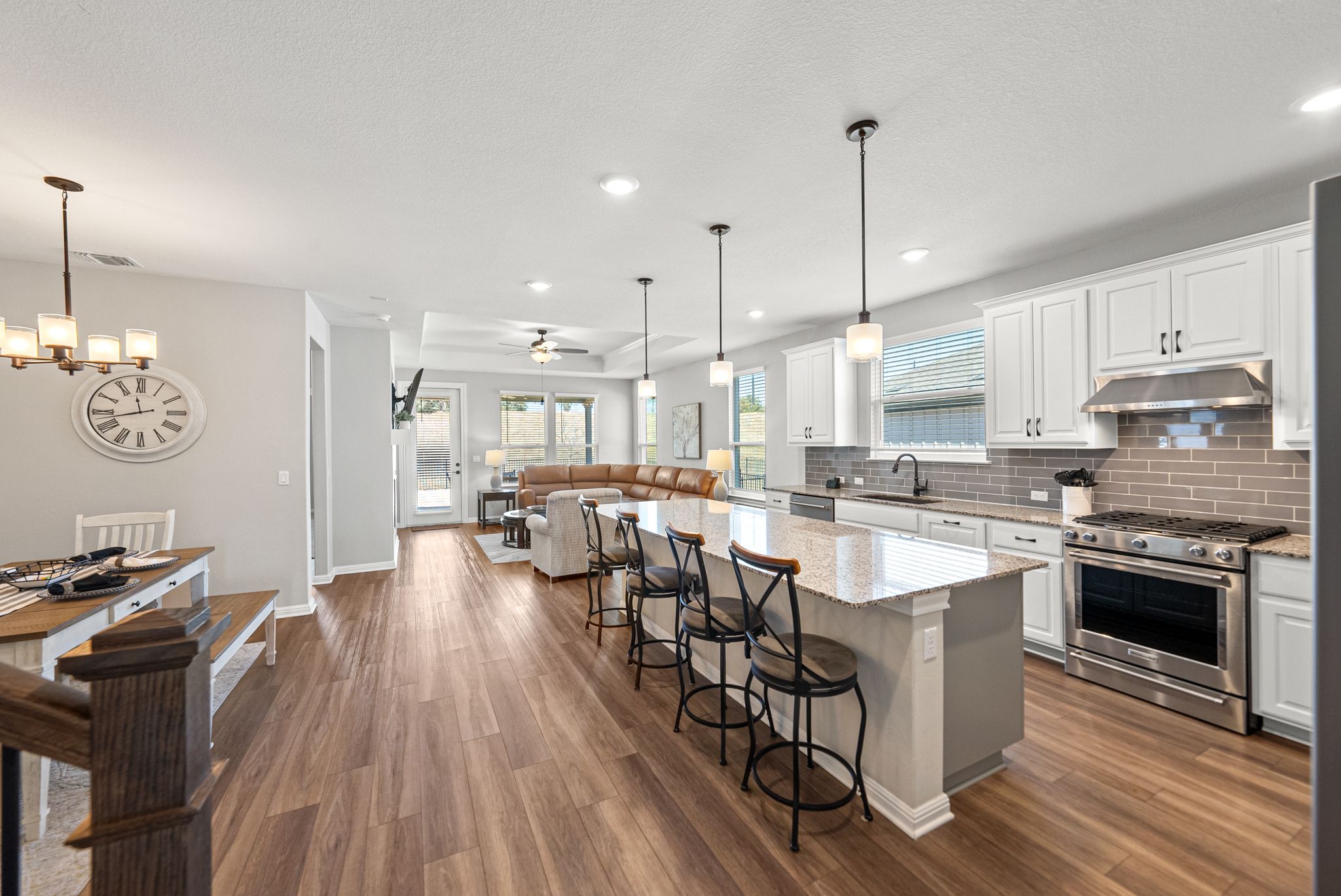 642 Martingale Street Georgetown, TX 78633 - Photo 7 of 40 The flawless kitchen has a massive granite island, sleek white cabinetry, and a designer tile backsplash, this space flows seamlessly into the dining and living areas so you’re always part of the conversation.