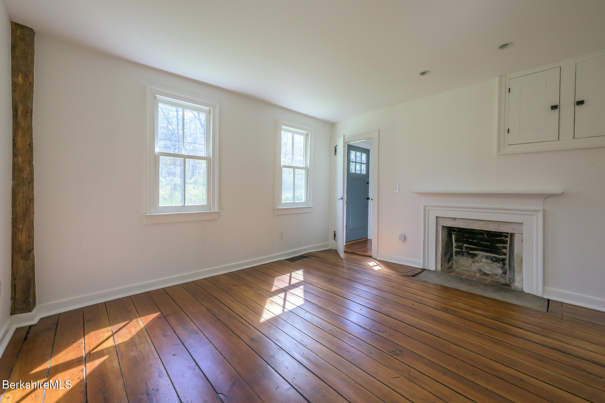 304 Hickey Hill Road Sheffield, MA 01257 - Photo 25 of 60 an empty room with wooden floor fireplace and windows