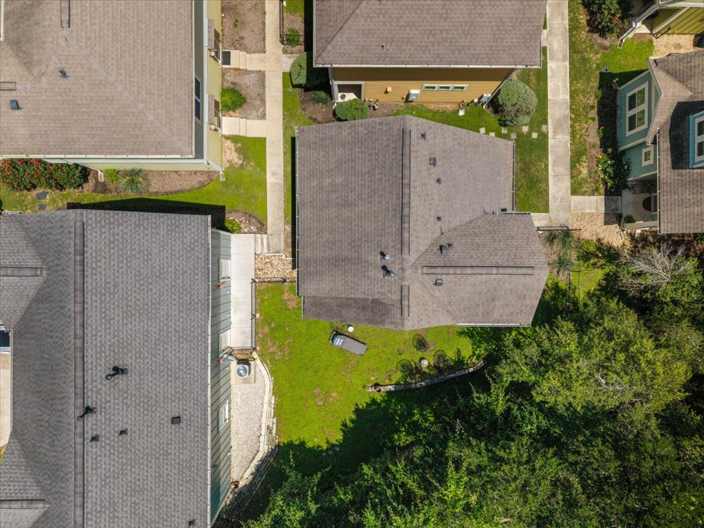 12200 Tawny Farms Road, Unit 139 Austin, TX 78748 - Photo 29 of 30 You can see how the property backs right up to the dense tree canopy. It also gives you a great look at your manageable, low-maintenance side and back lawns, the private fenced layout, and how cleanly the concrete walkways wrap around the home.