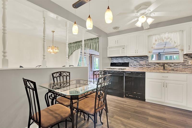 1409 Gill Hall Road Clairton, PA 15025 - Photo 8 of 29 a kitchen with granite countertop a stove a sink a dining table and chairs