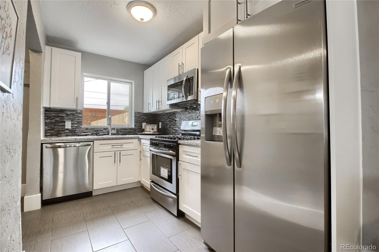 2821 Harrison Street Denver, CO 80205 - Photo 7 of 24 a kitchen with cabinets and stainless steel appliances