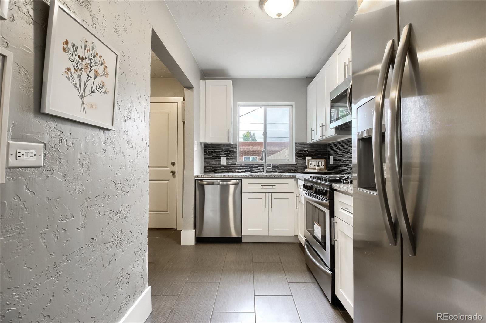 2821 Harrison Street Denver, CO 80205 - Photo 8 of 24 a kitchen with stainless steel appliances a refrigerator sink and stove