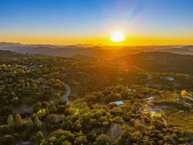 an aerial view of residential houses with outdoor space and ocean view