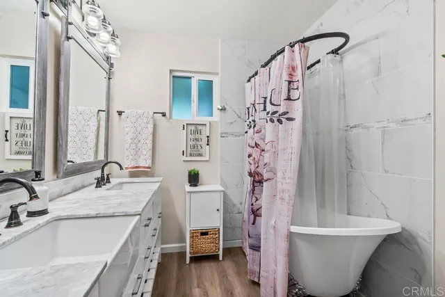 a spacious bedroom with a bed a couch and a dresser next to a window