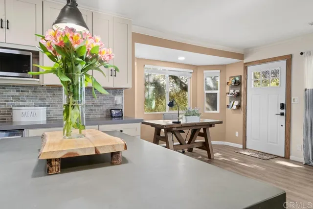 a kitchen with white cabinets stainless steel appliances and wooden floor
