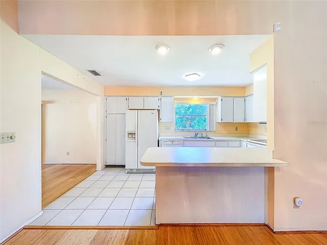 a view of kitchen with refrigerator and window