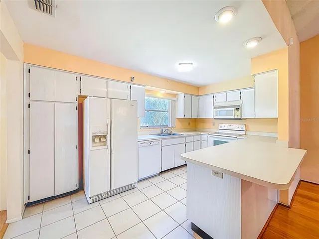 a kitchen with white cabinets and white appliances