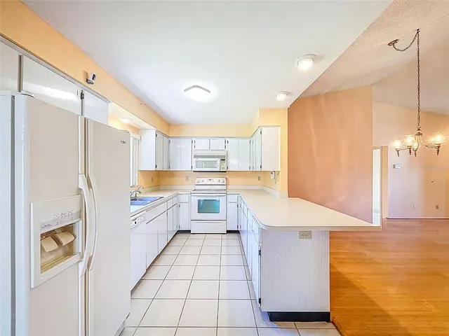 a large kitchen with a refrigerator a sink and dishwasher