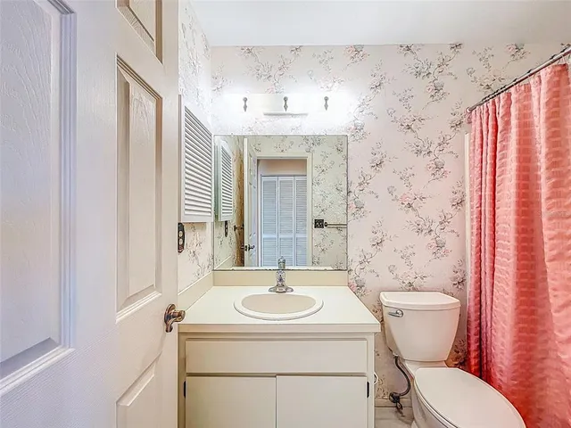 a bathroom with a sink toilet and mirror