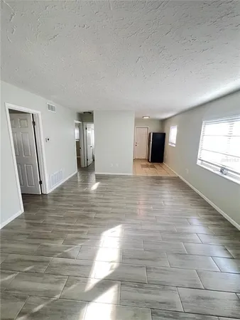 a view of empty room with wooden floor