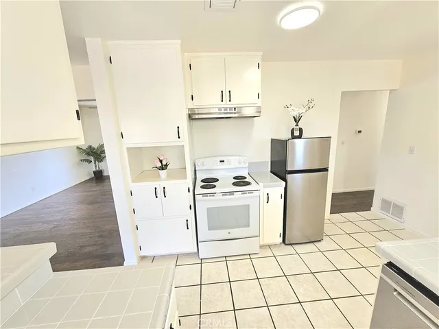 a kitchen with a refrigerator a stove top oven and a counter top space