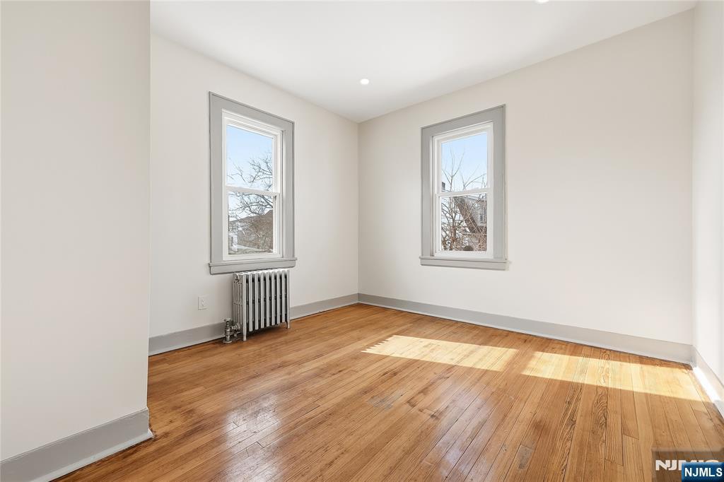 265 North 17th Street, Unit 2L Bloomfield, NJ 07003 - Photo 7 of 9 an empty room with wooden floor and windows