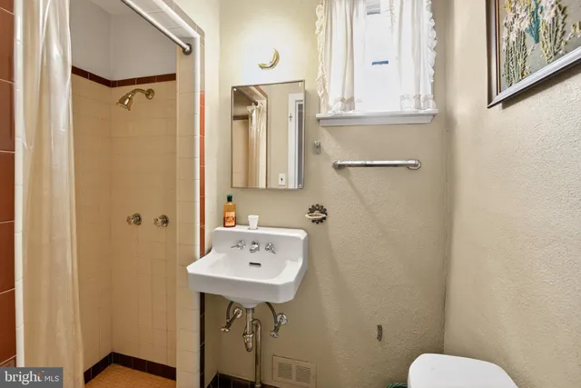 a bathroom with a sink a toilet and a mirror